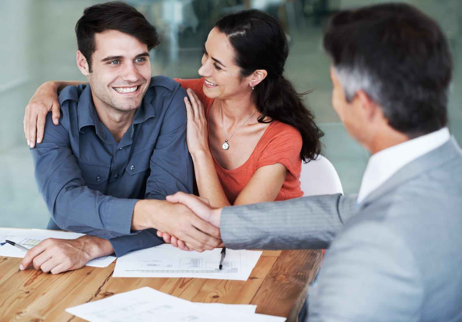 Avoiding Costly Errors with Professional Advice Image of a couple shaking hands with a financial advisor, reviewing documents for a loan, agreement, and contract, featuring the 411 Divorce logo and highlighting 'Avoiding Costly Errors with Professional Advice,' aligning with the page's focus on the importance of expert guidance during divorce financial decisions.