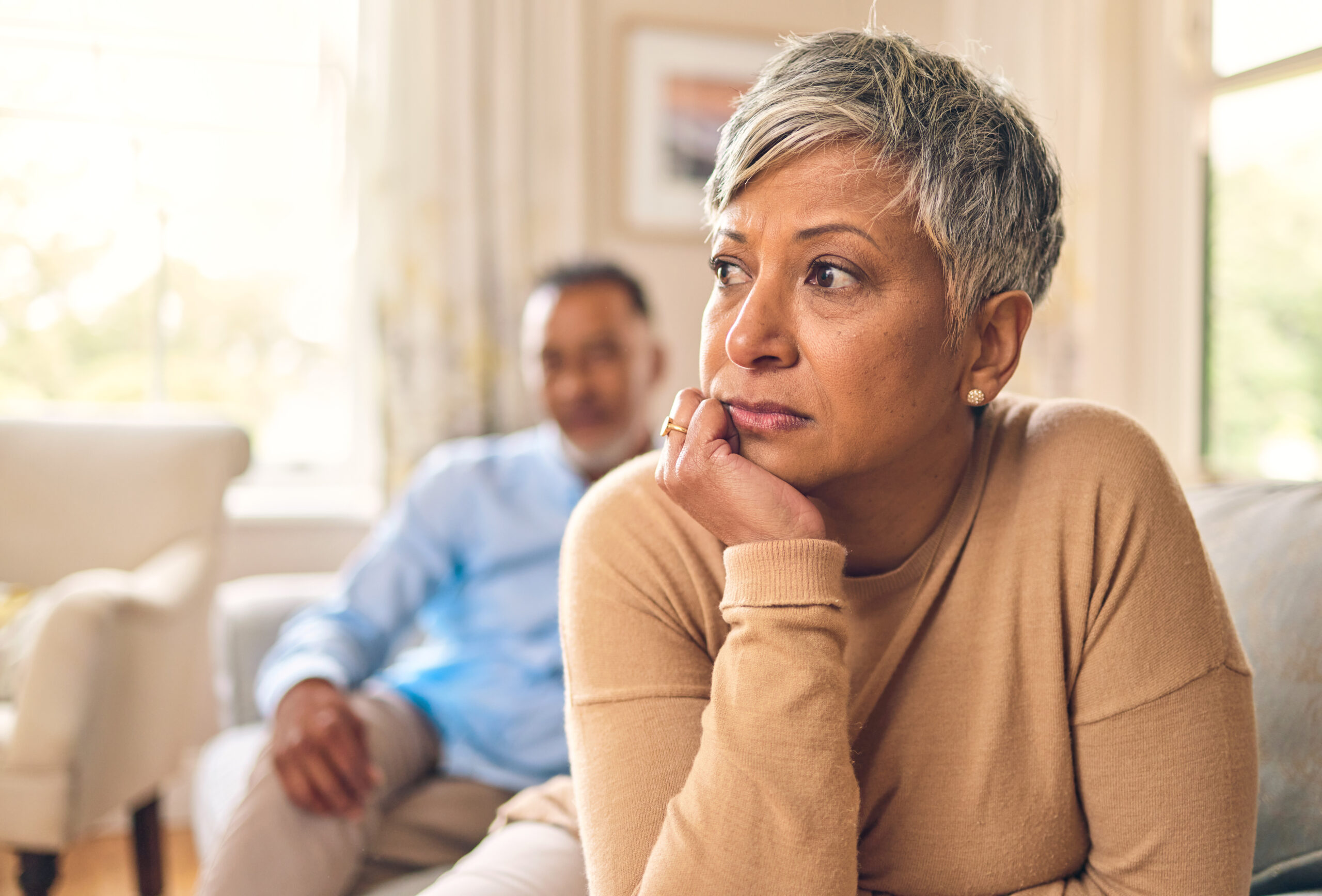 Divorce, fight and mature woman is sad in living room with partner at home with depression or thinking. Conflict, wife and marriage with infidelity is upset on sofa with couple, cheating, frustrated. Creating a Post-Divorce Budget