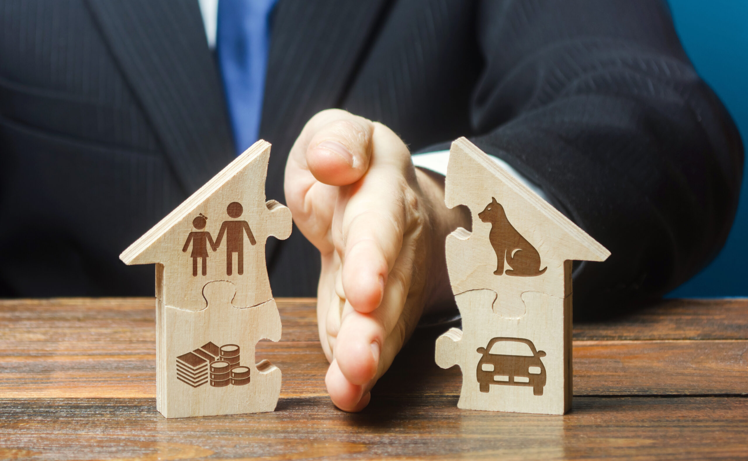 Puzzle house is divided into two equal parts by a lawyer in a divorce process. Protection of rights. Conflict resolution. Court, justice. Disputes over fair division of marital property real estate. Division of Assets and Debts