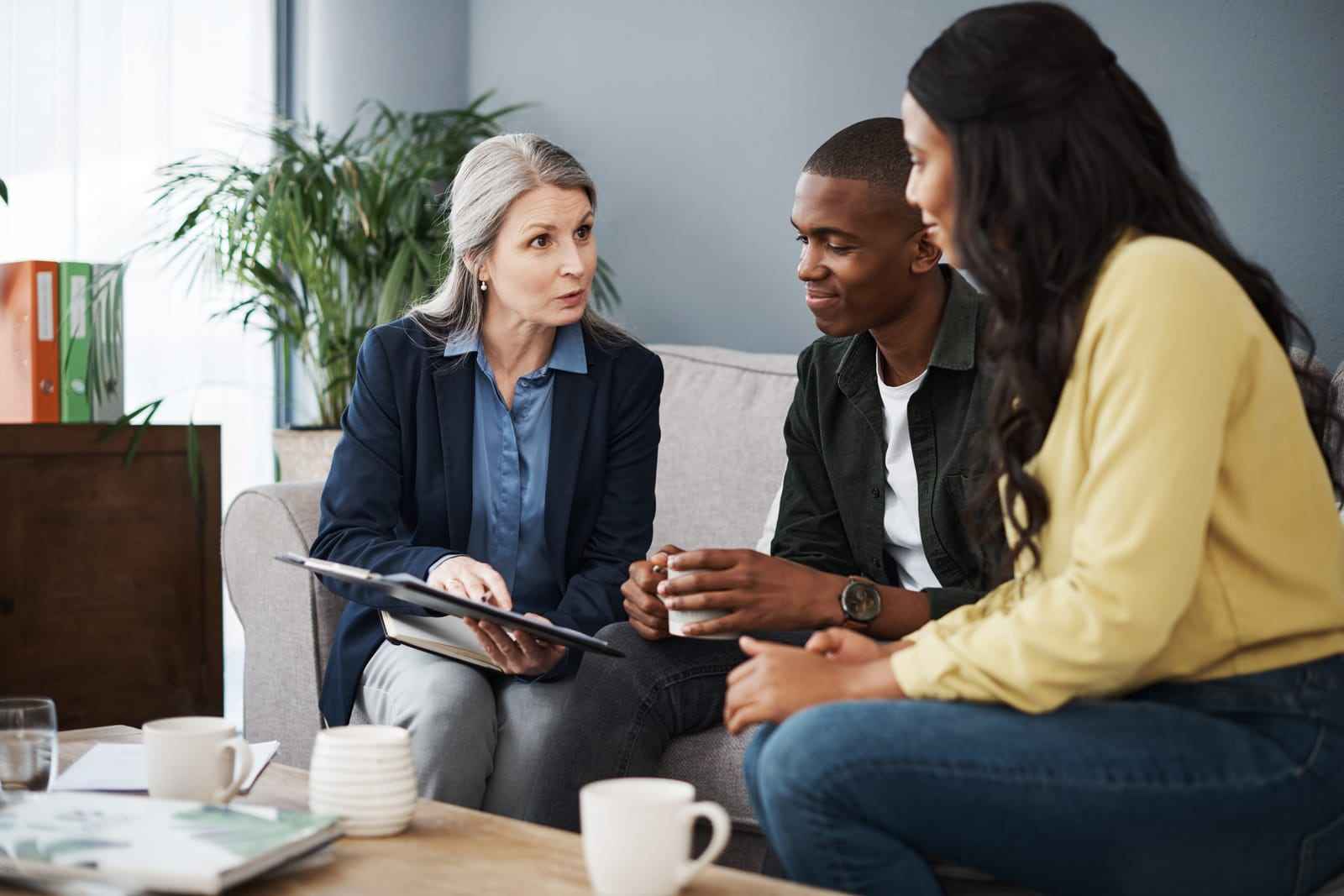 Image of a couple discussing with a financial advisor, reviewing documents for budget advice, prenup, and will in a home setting, featuring the 411 Divorce logo and highlighting 'How an Attorney Can Help in Each Step of Divorce,' aligning with the page's focus on legal guidance during divorce proceedings.