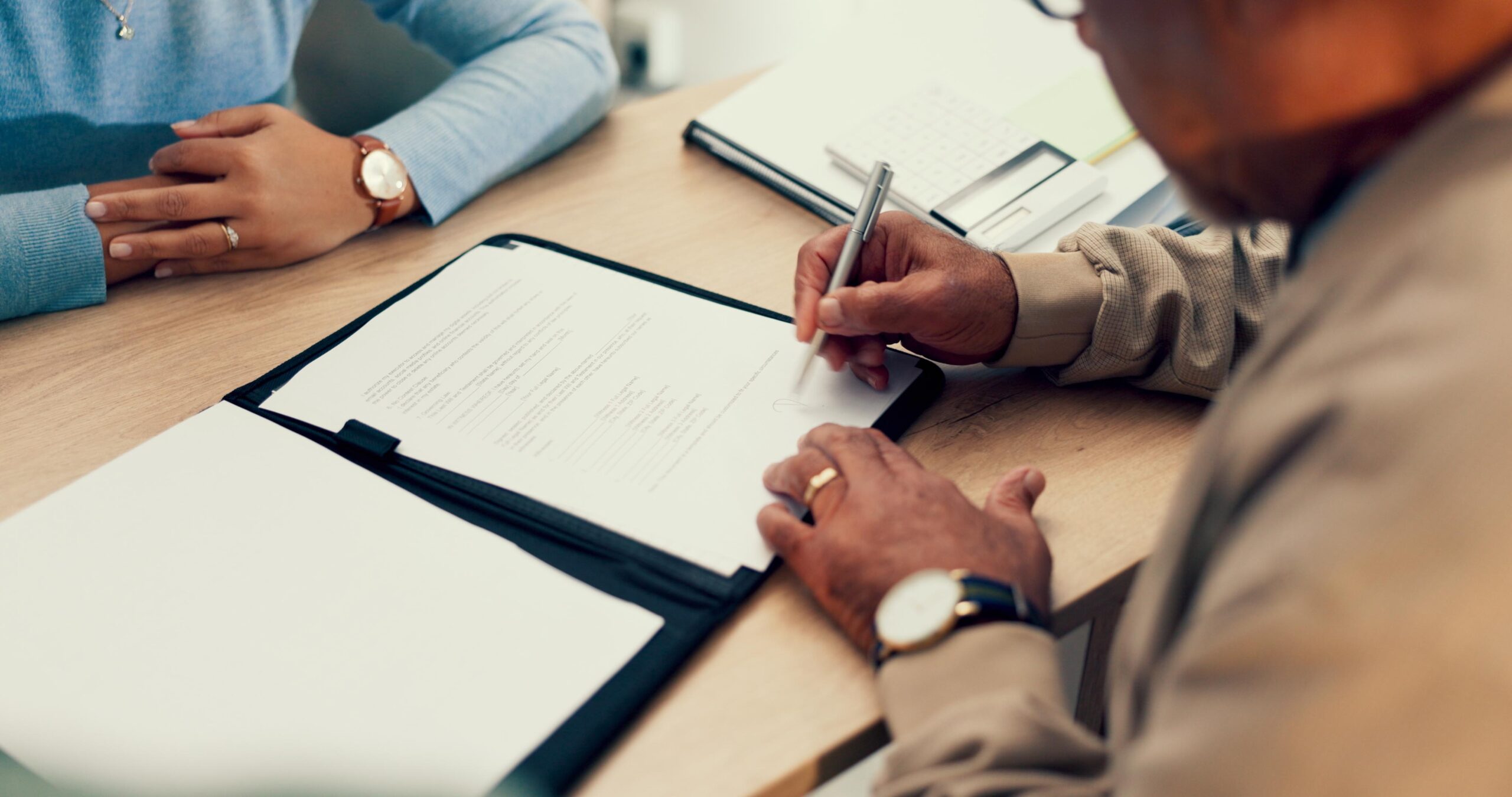 Hands, lawyer or man with contract for signature, application and writing on document of insurance or legal paperwork. Attorney or notary with client for agreement of document, policy or title deed What to Look for in a Financially Savvy Divorce Attorney
